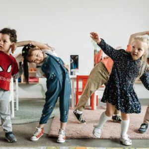 Group of diverse preschool children engaging in fun exercises indoors.